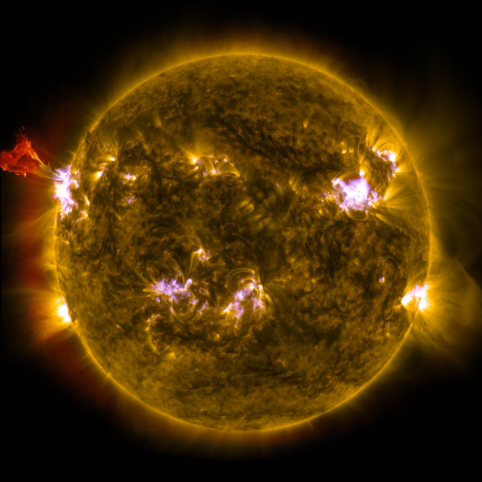 A vast arc of glowing solar material erupting from the edge of the Sun against black space, curving away in bright filaments before falling back.