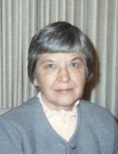Portrait photograph of Stephanie Kwolek in 1986, seated against a curtain, wearing a grey cardigan over a pale blouse.